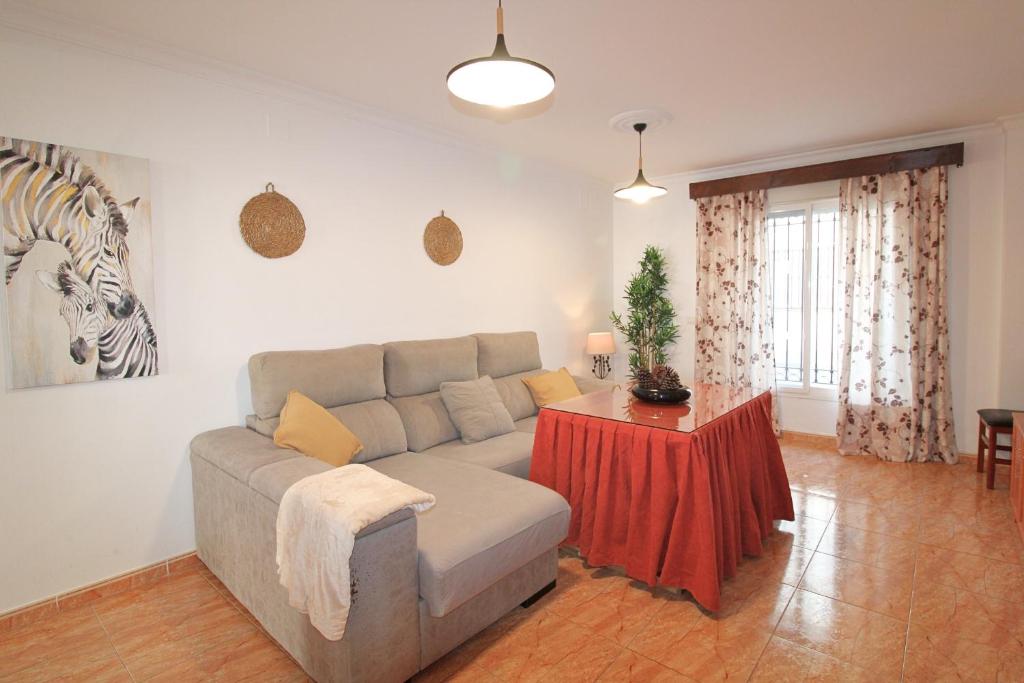 una sala de estar con un sofá y una mesa en Apartamento Tenerías Gruta by SIERRA VIVA, en Aracena