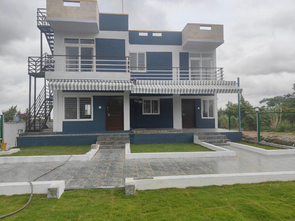 een groot blauw huis met een trap ervoor bij Nandi Parihar Villa 1 in Bangalore