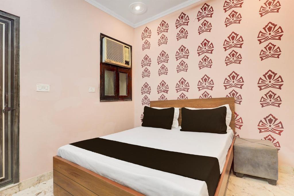 a bedroom with a bed and a wall with patterns at Hotel O Vishal plaza in New Delhi