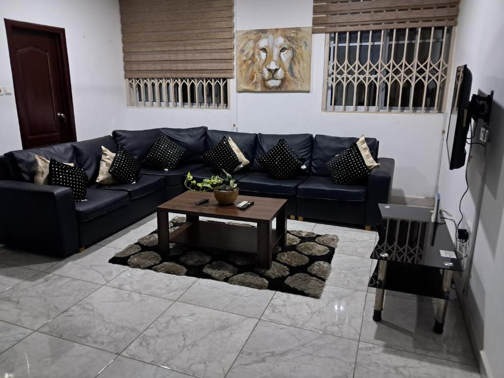 a living room with a blue couch and a table at Douglas Luxury Apartments At Douglas Court, Adenta, Accra in Accra