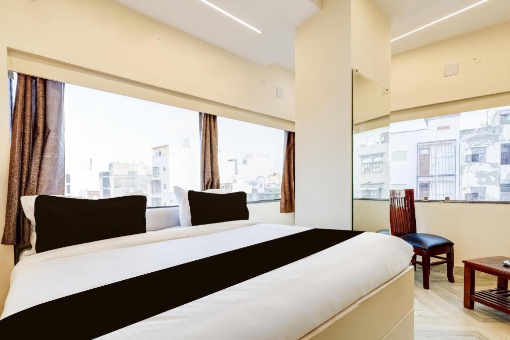 a bedroom with a large bed and a large window at Hotel O Roux residency in New Delhi