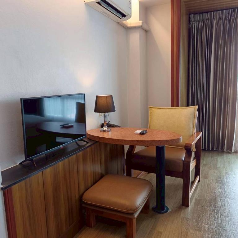 A compact in-room sitting and work area beside the television.