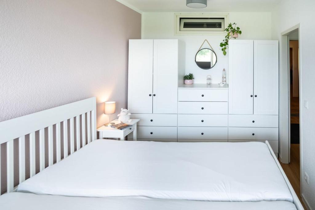 1 dormitorio con 1 cama blanca y vestidor blanco en Vogelsand - 328, en Cuxhaven