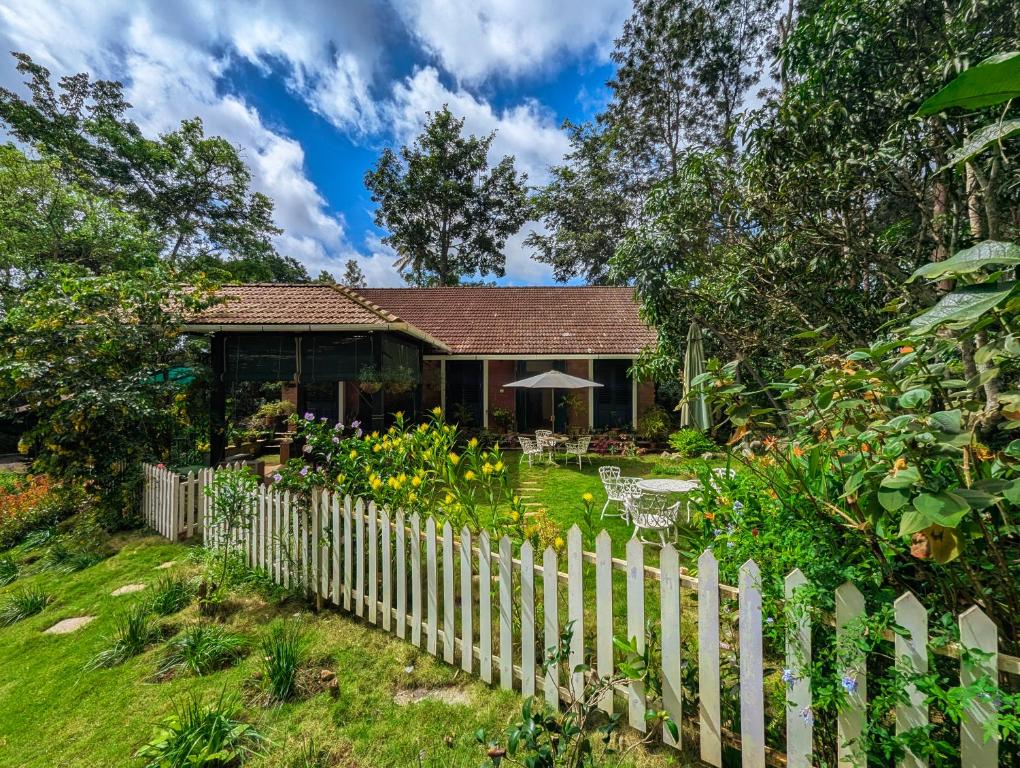 a white picket fence in front of a house at Pine Tree Place By Luxunlock Private Villas in Ammatti