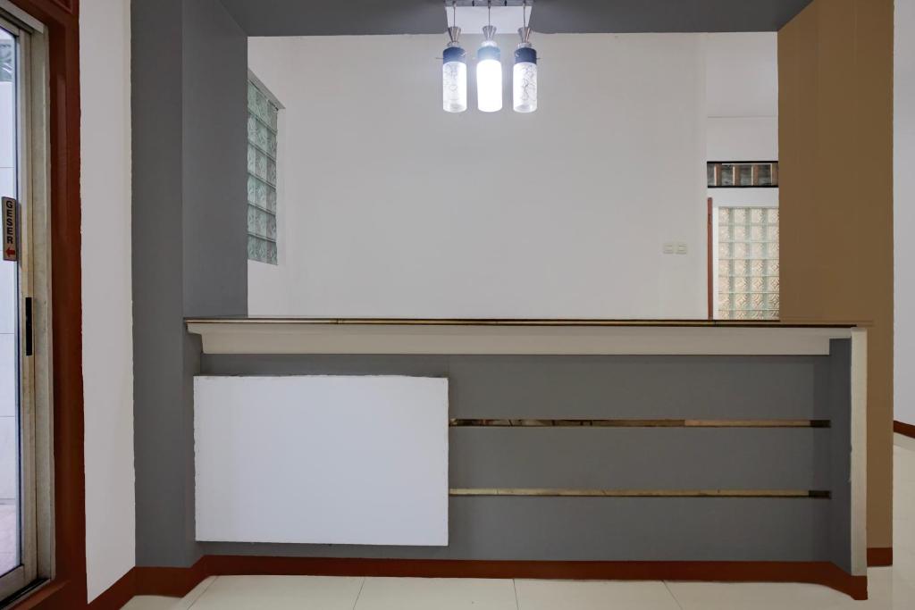 a white counter in a room with a wall at Hotel O Medan near Sun Plaza formerly Medan Baru House in Medan