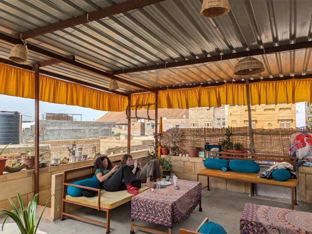 two women sitting on a couch on a patio at Ok-An Homestay in Jaisalmer
