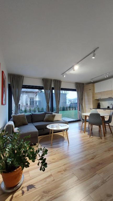 a living room with a couch and a table at Apartament Zakatek 2 z ogrodkiem i miejscem w garazu podziemnym in Bielsko-Biala