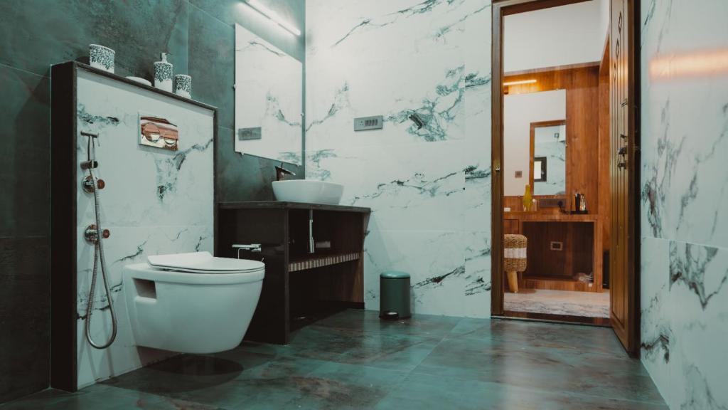 a bathroom with a toilet and a sink at The Wild Rest Nature Resort in Avathi