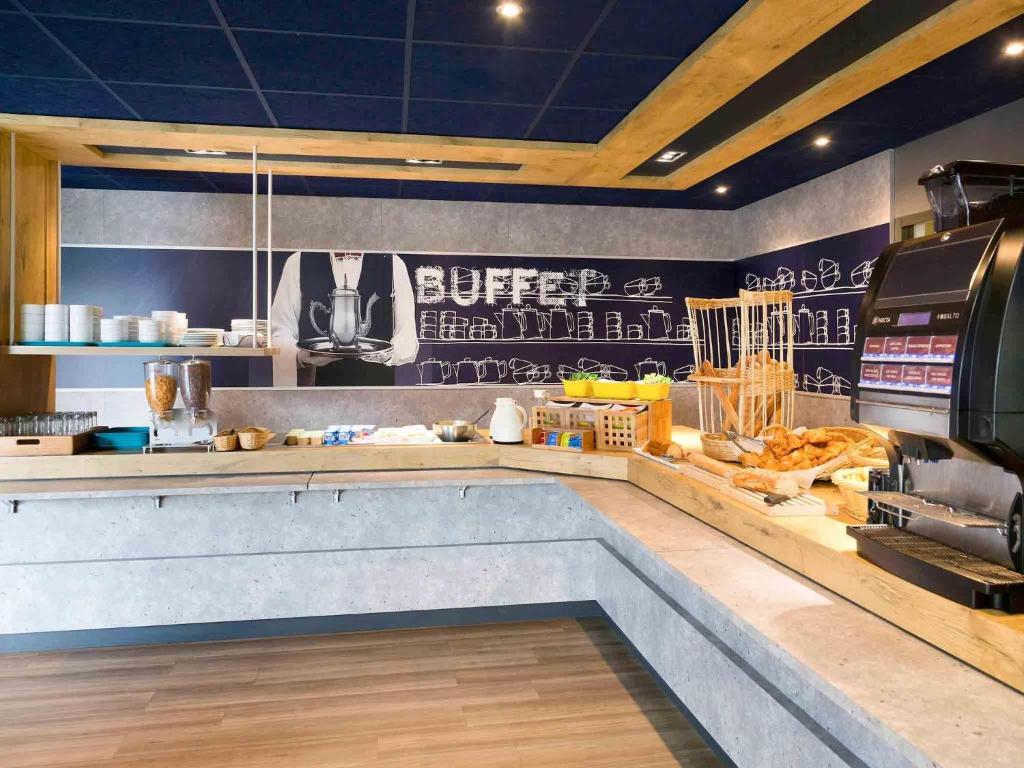 a fast food restaurant with a counter with food at Ibis Budget Saint Malo Centre in Saint Malo