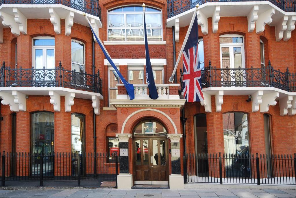 two flags flying in front of a brick building at The Harrington Residences in London