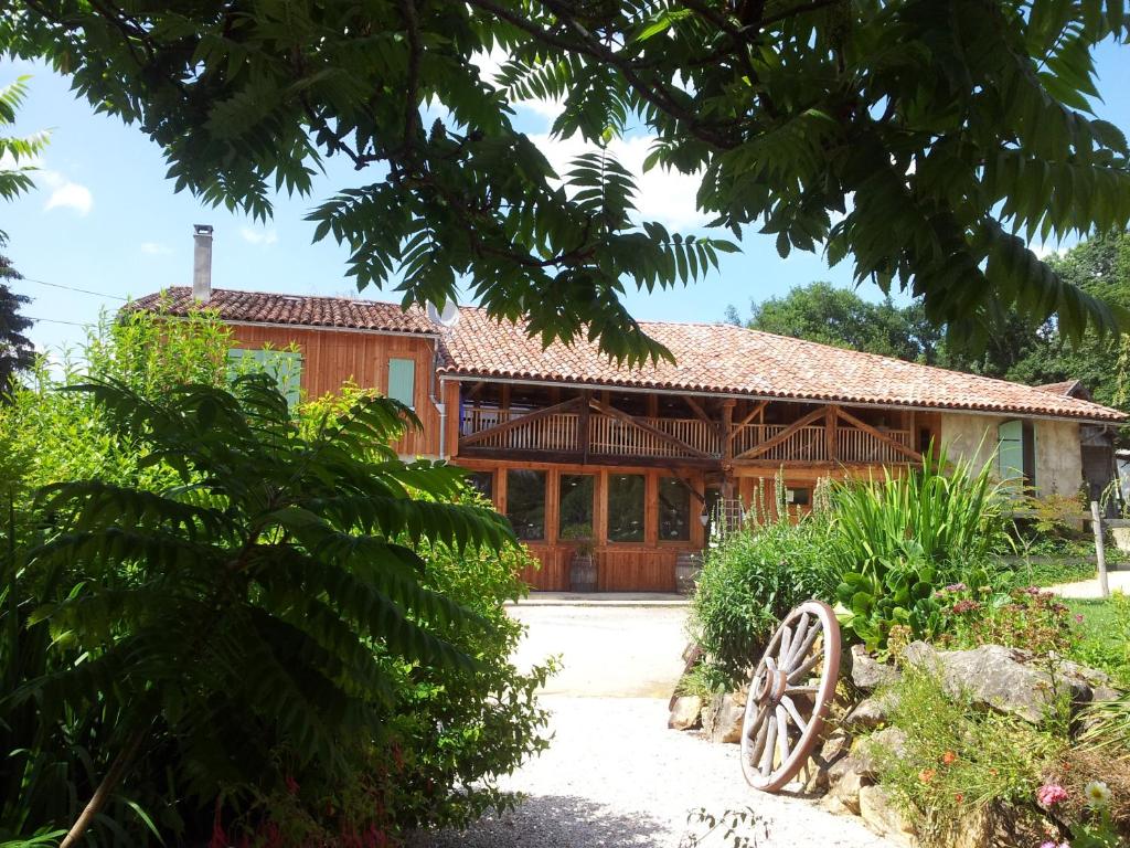 une maison en bois avec une roue devant elle dans l'établissement Chambres d'hôtes St Jacques Adults only, à Saint-Lizier