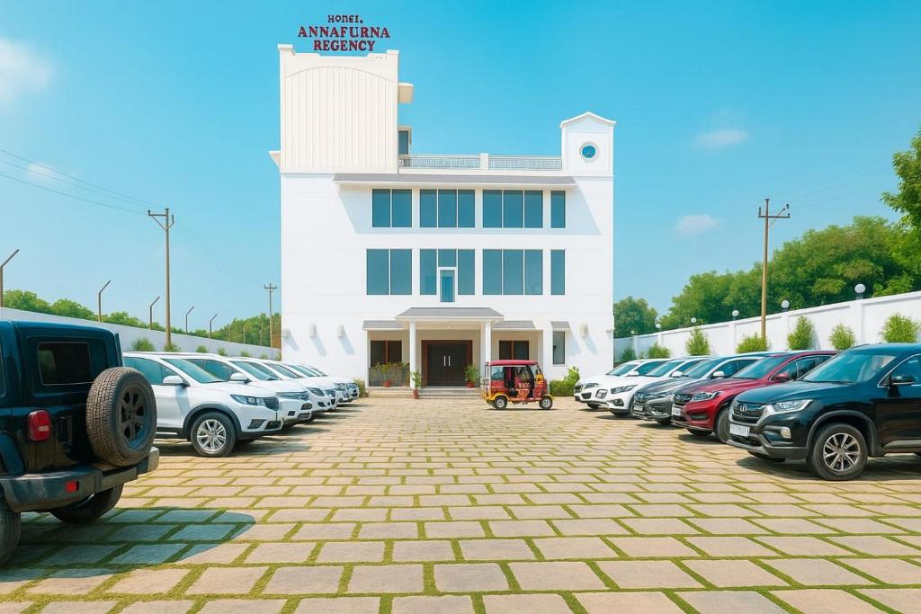 a parking lot with cars parked in front of a building at Hotel Annapurna Regency in Mirzāpur