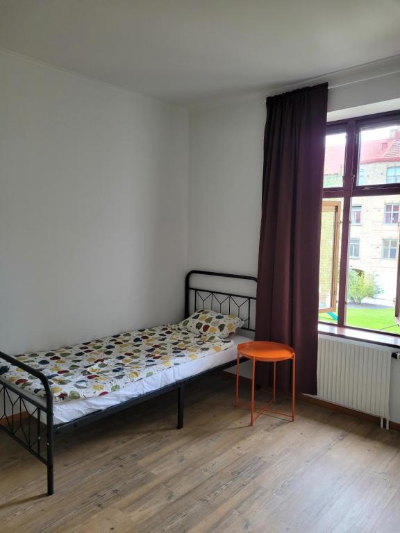 a bedroom with a bed and a chair and a window at Cozy & light-filled home in Landskrona