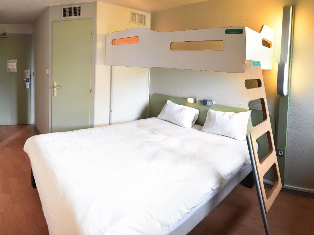 a bed in a room with a bunk bed at Hotel ibis Budget Laval in Bonchamp-lès-Laval