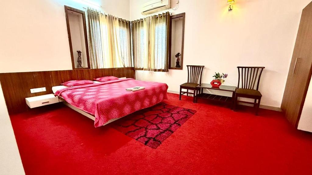a bedroom with a bed and a red carpet at Hotel Mahendra, Karad in Karad