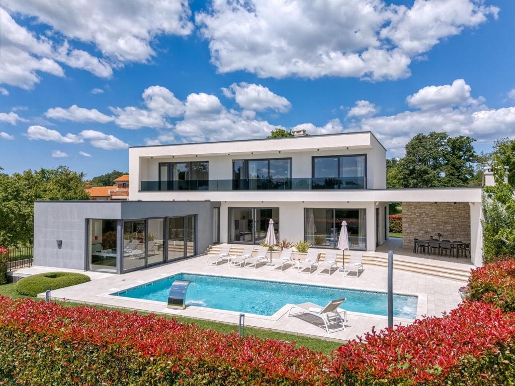 a house with a swimming pool and a villa at Contemporary Villa Nada with Pool and Sauna in Tinjan