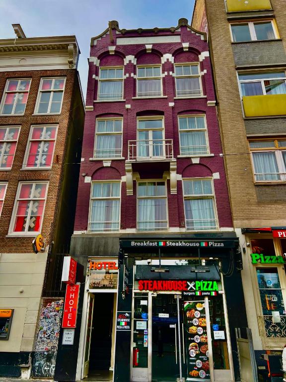 a tall building with a store in front of it at Orange Tulip Hotel in Amsterdam