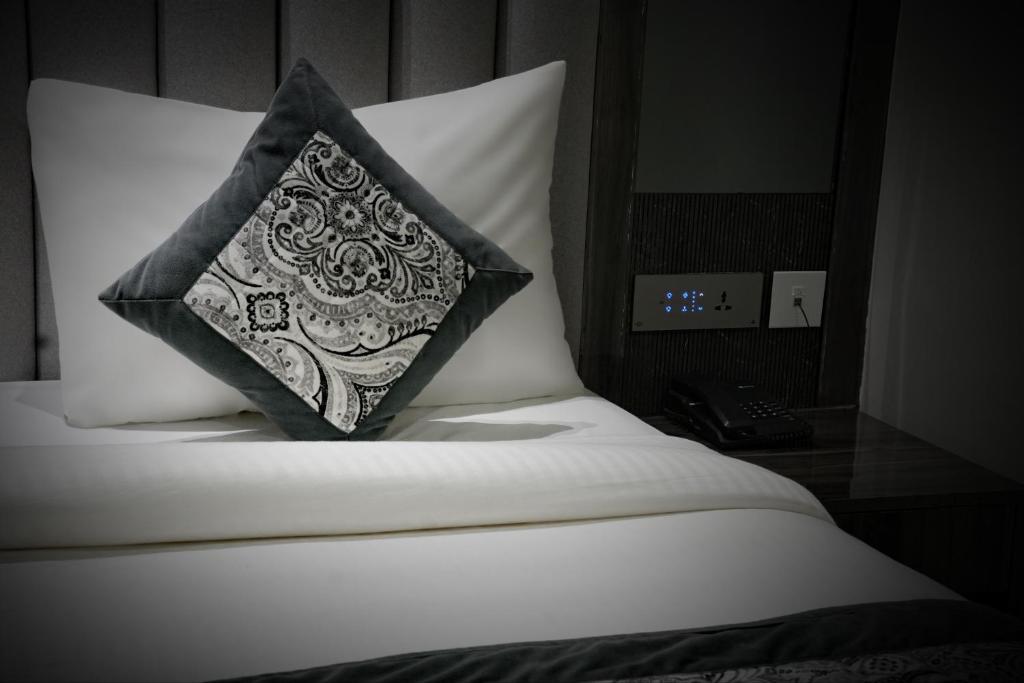 a black and white pillow sitting on top of a bed at Hotel Bliss express' New delhi city center in New Delhi