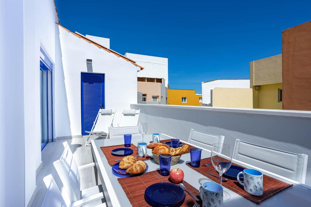 einen Tisch mit Brot und Weingläsern auf dem Balkon in der Unterkunft Playa Jardín Sun & Dreams in Puerto de la Cruz