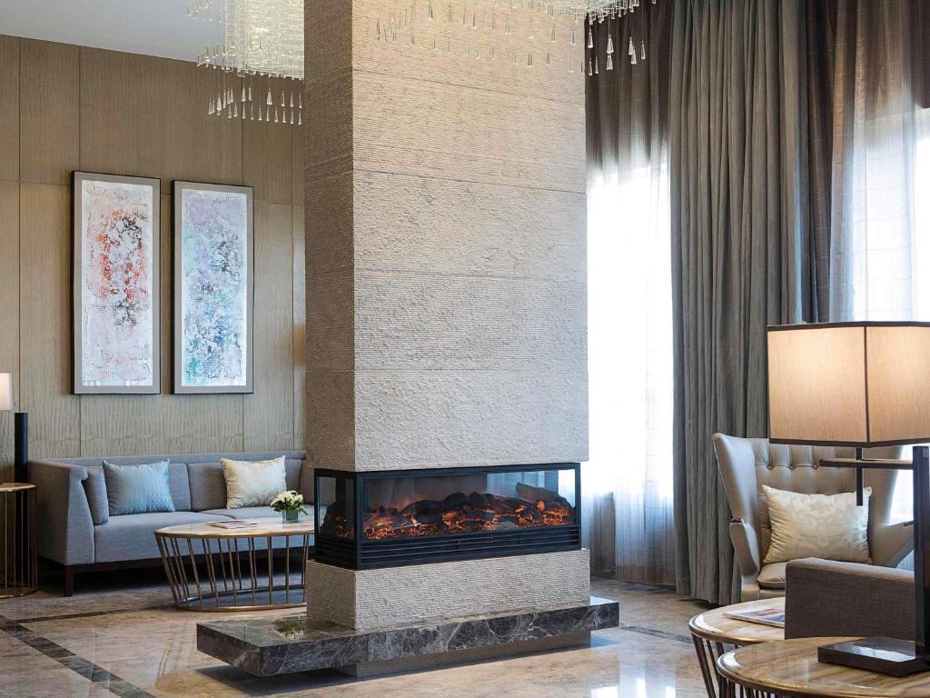 Una sala de estar con chimenea y un sofá. en Pullman Taiyuan, en Taiyuán