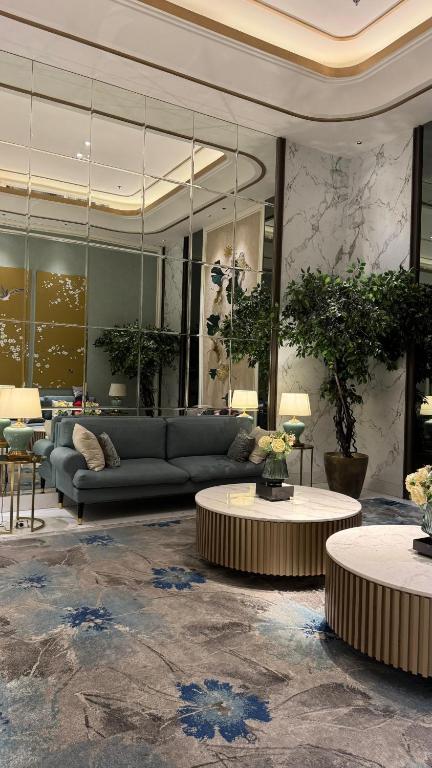 a living room with a couch and two tables at Apartemen Anderson pakuwon mall Luxury Studio Apartment Connecting Mall, Pool & City View 37B in Surabaya