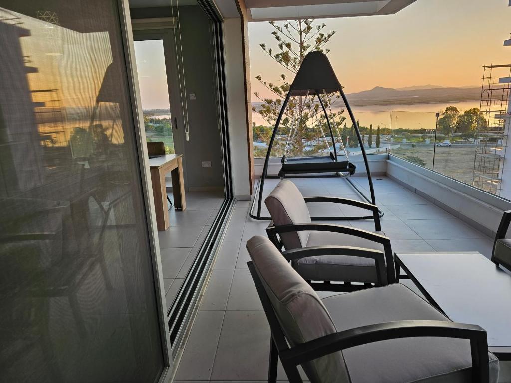 a balcony with chairs and a view of the ocean at Majestic Sunset Salt Lake Views 300m From Beach in Larnaka