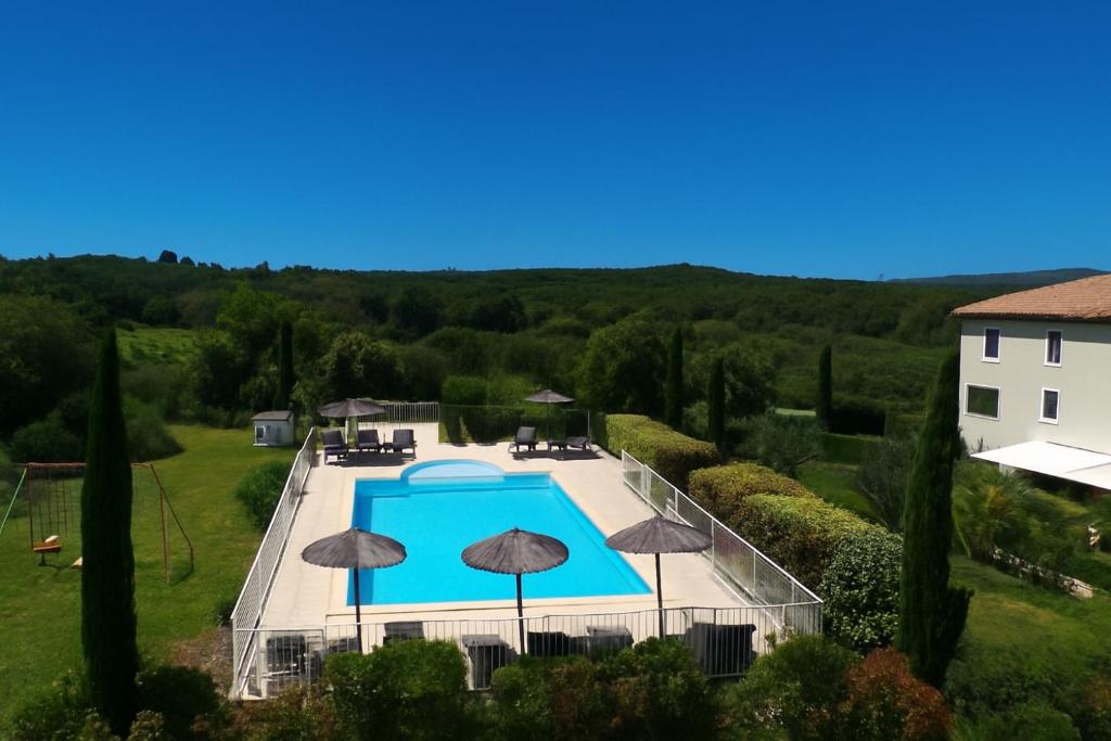 eine Draufsicht auf einen Swimmingpool mit Sonnenschirmen in der Unterkunft Hotel Restaurant Le Gardon - Pont du Gard in Collias