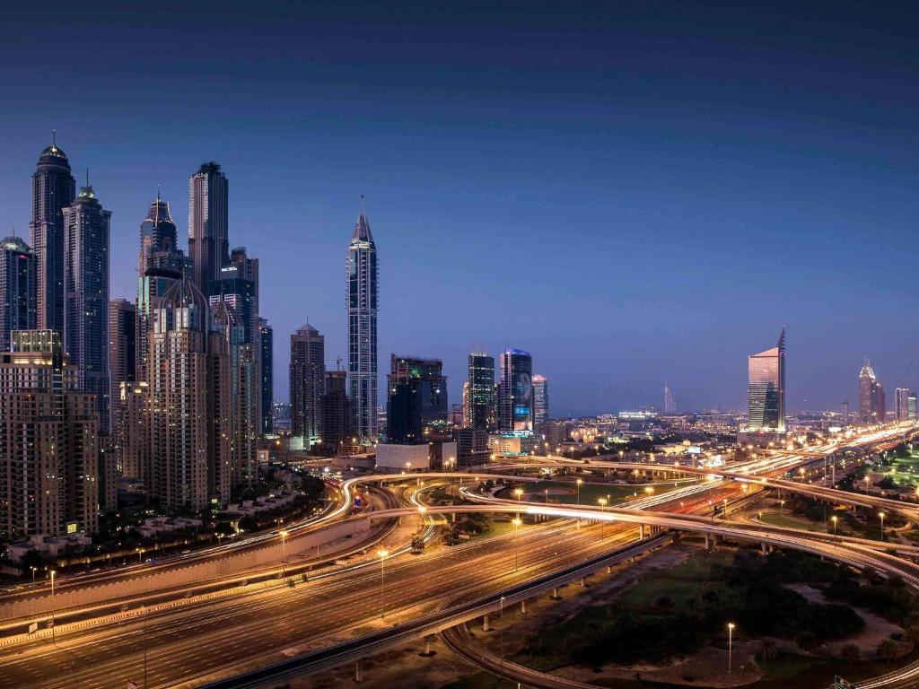 a night view of a city with traffic on a freeway at Pullman Dubai Jumeirah Lakes Towers in Dubai