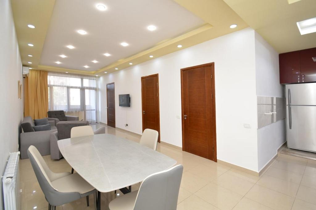 a dining room with a white table and chairs at Stylish 3 room ap near republic square in Yerevan