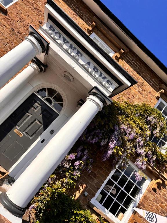a building with white columns and flowers on it at The Boyne Arms in Burwarton