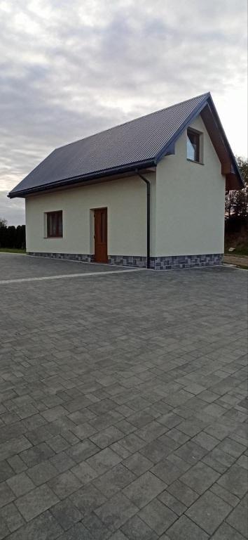 a large white building with a black roof at Willa Gorce in Ostrowsko