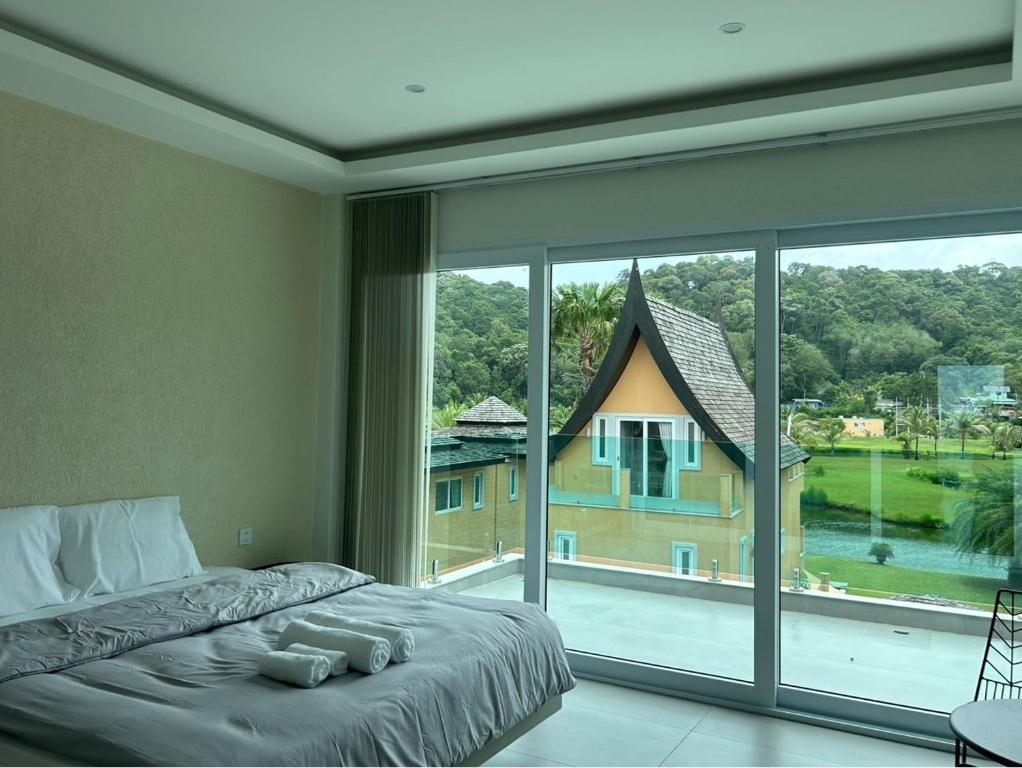 Un dormitorio con una cama y una ventana grande. en Cozy View Pool Villa - Koh Chang, en Ban Khlong Son