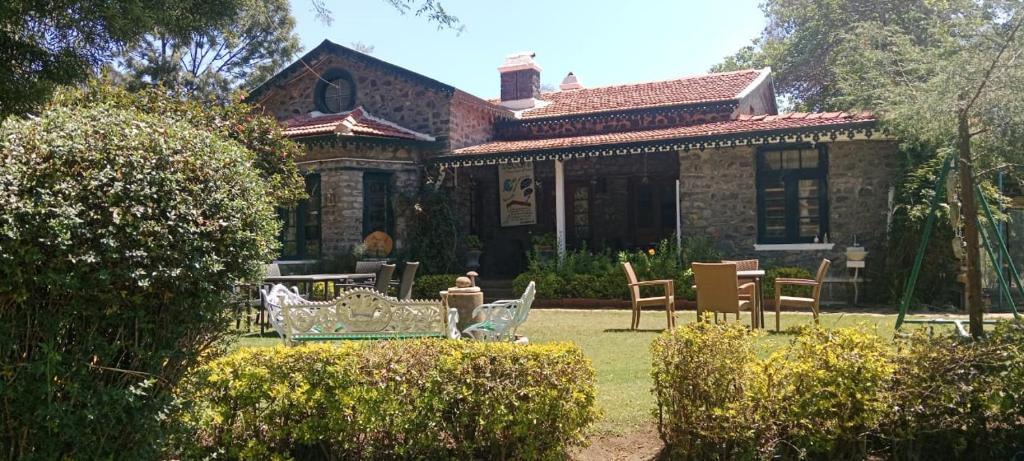 a house with chairs and tables in front of it at Ksr woodland Residency in Kodaikānāl