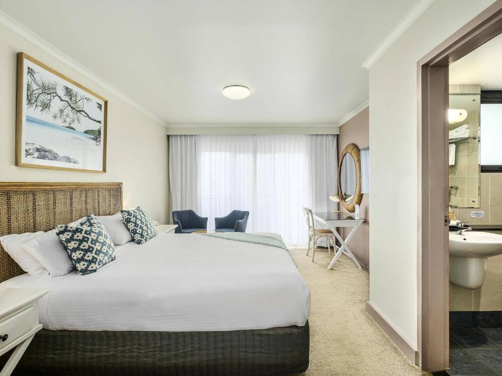 una habitación de hotel con una cama y un baño en ibis Styles Port Macquarie, en Port Macquarie