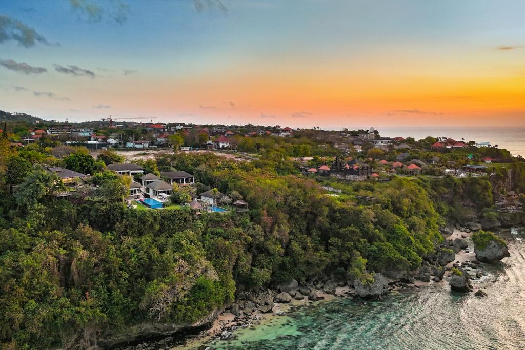 eine Luftansicht einer Stadt auf einem Hügel neben dem Meer in der Unterkunft Suluban Cliff Bali Villa in Uluwatu