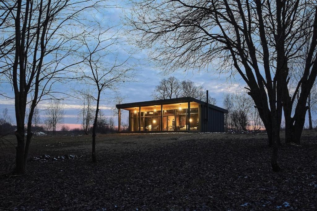 a large glass house in a field with trees at The Barn 