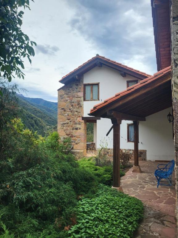 a house with a blue bench in front of it at Explora Picos de Europa in Cosgaya