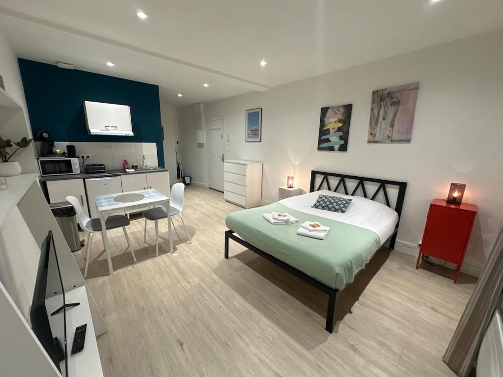 a bedroom with a bed and a kitchen with a kitchenstration at C Helsinki - Studio cosy près du centre-ville in Charleville-Mézières