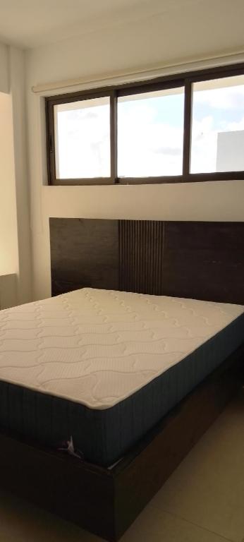 a bed in a room with a window at Lee's Mombasa Havenstays in Kanga