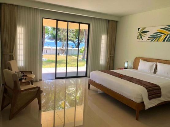 um quarto com uma cama e uma porta de vidro deslizante em K's Beach Resort em Lovina