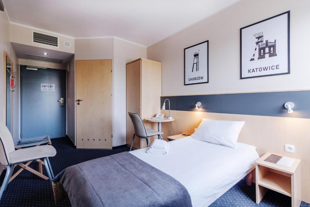 a hotel room with a bed and a table and chairs at Economy Silesian Hotel in Katowice
