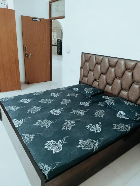 a bed with a black and white blanket on it at Syno in Lucknow