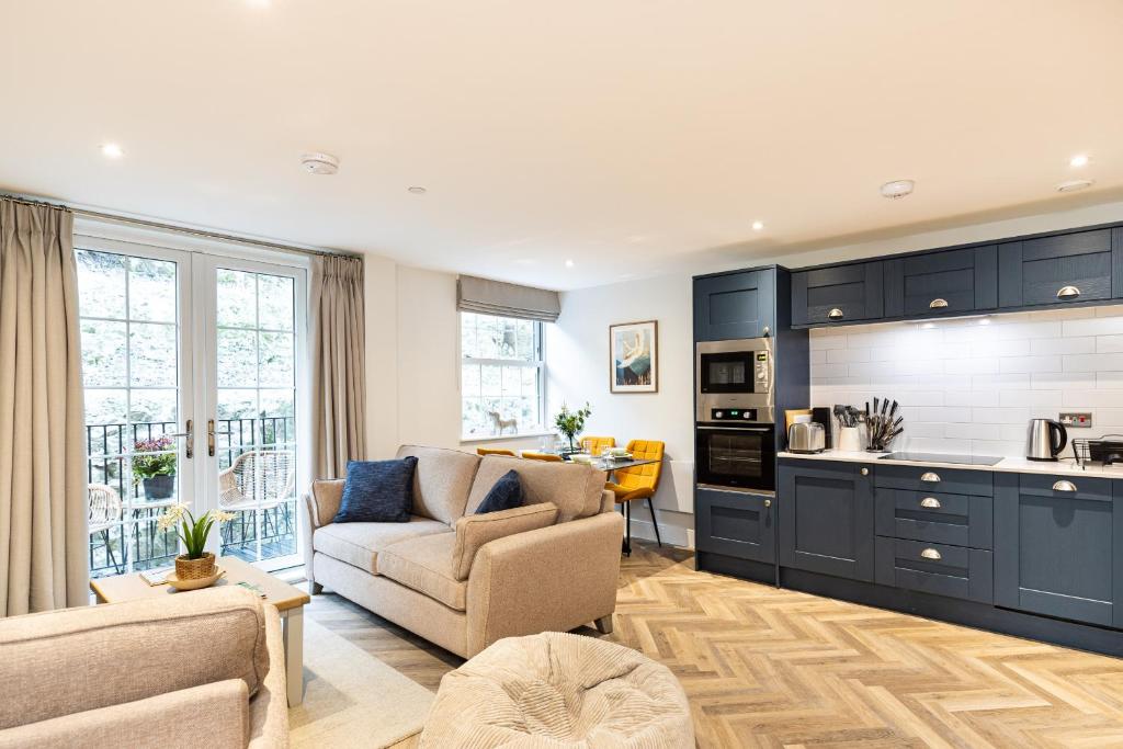 a living room with a couch and a kitchen at Rock Mill 2 Bed Apartment 22 in Stoney Middleton