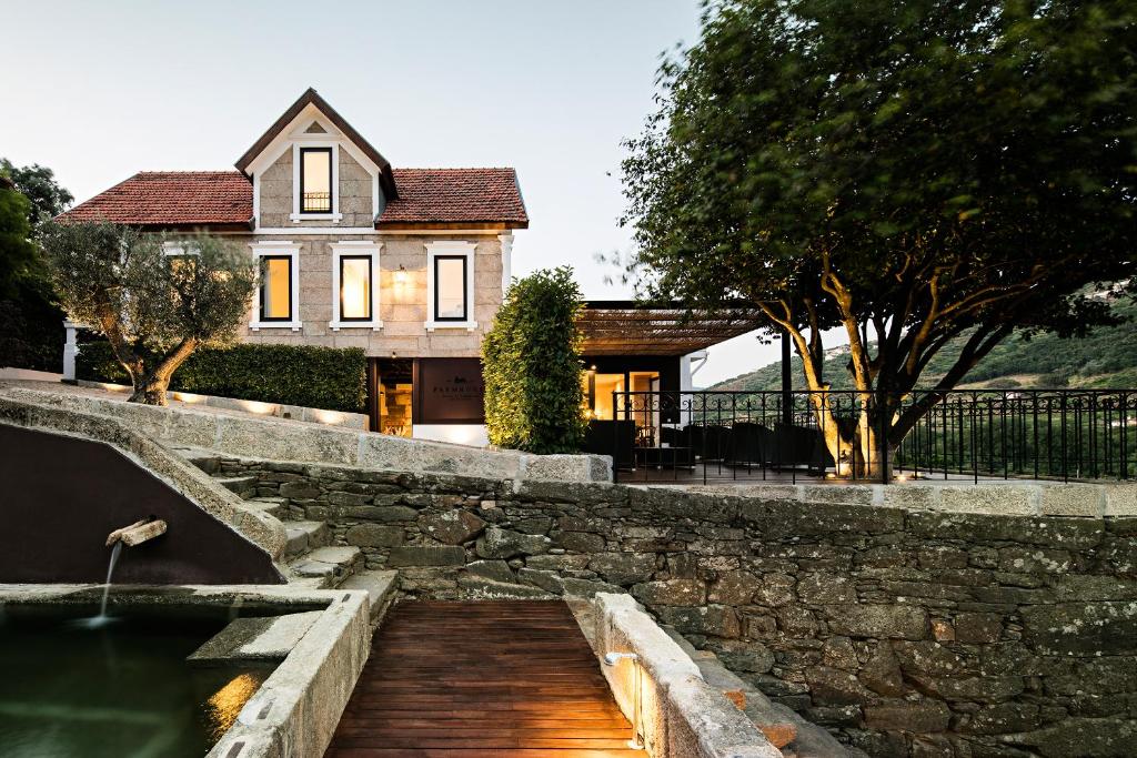 une maison avec un étang en face d'une maison dans l'établissement Quinta de S.Bernardo - Winery & Farmhouse, à Mesão Frio