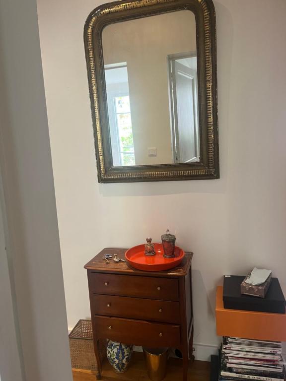 a mirror over a dresser with a plate on it at Bedroom in Paris in Paris