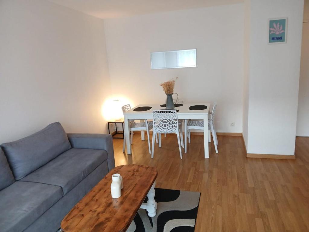 a living room with a couch and a table at F2 plein sud proche plage du débarquement in Port-en-Bessin-Huppain
