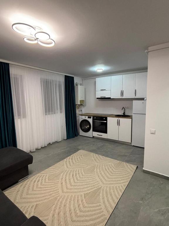 a living room with a kitchen with white cabinets at Cozy Apartment Mureseni in Târgu-Mureş