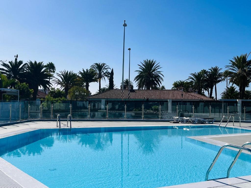 a large swimming pool with palm trees in the background at Santa Barbara Tropical by Alquiler de Sueno - 2 private terraces in Playa del Ingles