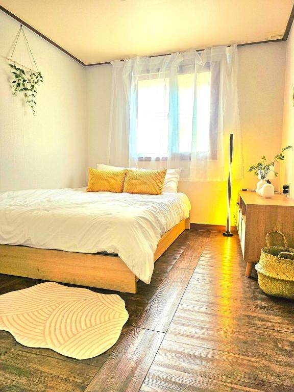 a bedroom with a large bed and a window at k조이스테이 in Pongsan-dong