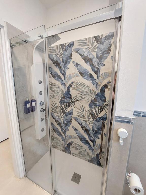 een douche met een glazen deur met een muurschildering van bladeren bij Blue Iris - Varese - Laghi Svizzera in Varese